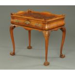A George III style walnut silver table, the rectangular top being crossbanded and with gallery,