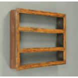 An 18th century provincial oak open wall rack, with moulded frame and three shelves.