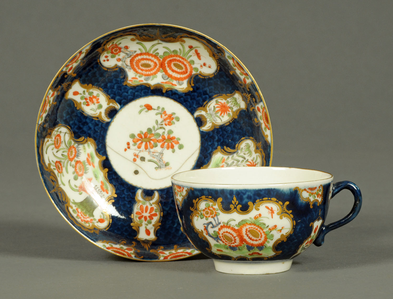 A Worcester Scale Blue porcelain tea cup and saucer, decorated in the Japanese Kakiemon style.
