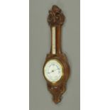 An Edwardian oak cased banjo aneroid barometer. Height 91 cm.