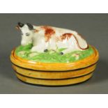 A 19th century Staffordshire Pottery butter dish, with sponged decoration and cow to lid,