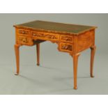 A walnut writing table, with serpentine front and black leatherette writing surface,