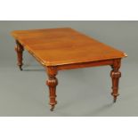 A Victorian mahogany wind out dining table, with two leaves,