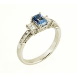 An 18 ct gold emerald cut tanzanite ring, with diamond set shoulders, size L/M (see illustration).