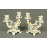 A pair of Sitzendorf twin branch candelabra, with floral encrustations and cherubs. Height 17 cm.