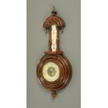 An early 20th century walnut aneroid barometer with mercury thermometer, in carved case. Height 46.