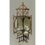 An Edwardian bamboo and lacquered corner hanging mirrored and shelved bracket. Height 94 cm.