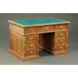 A late Victorian oak pedestal desk, with carved edge,