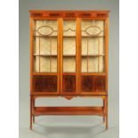 An Edwardian inlaid mahogany display case, with three quarter glazed doors,