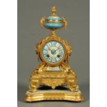 A 19th century French spelter and porcelain panelled mantle clock, raised on a wooden base,