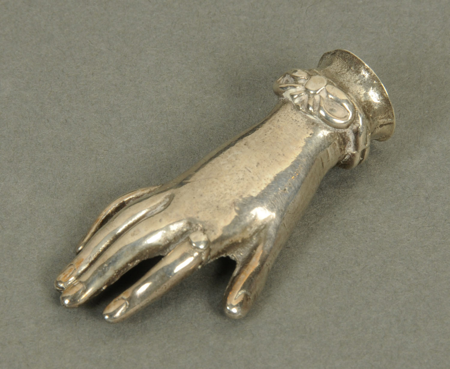 A silver coloured metal desk seal, in the form of a hand. Height 48 mm.