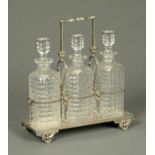 An Edwardian decanter stand, three decanters housed in a plated frame. Length 32 cm.