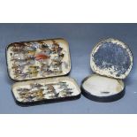 Black Japanned fly box containing salmon flies and circular Japanned cast wallet.