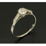 An 18 ct gold and platinum solitaire diamond ring, with diamond set shoulders, size T.