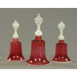 A set of three 19th century cranberry and milk glass bells. Tallest 35 cm.