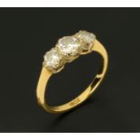 An 18 ct gold three stone diamond ring, size N.