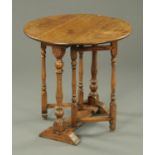 An 18th century oak gate leg table, twin drop flap, with turned supports.