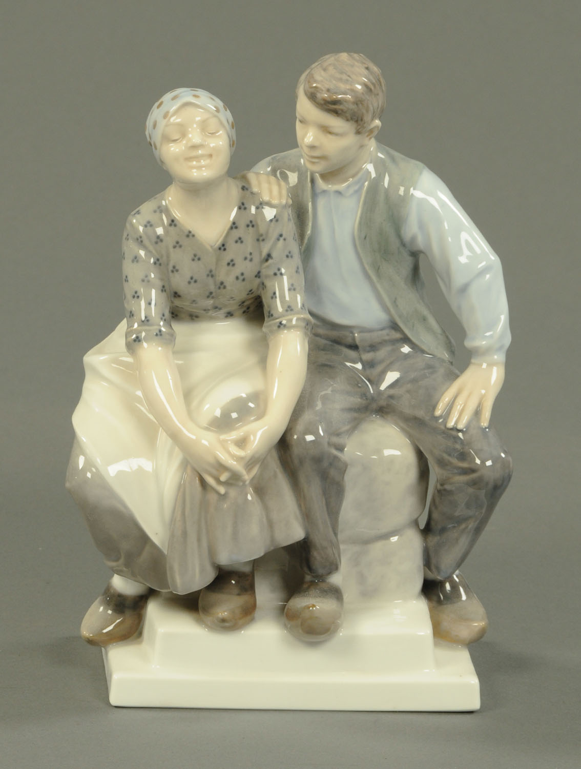 A large Royal Copenhagen figure group, seated couple wearing clogs.