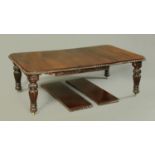 A Victorian oak extending dining table, with four leaves,