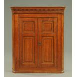 A George III oak hanging corner cupboard,