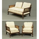 An early 20th century mahogany three piece Bergere lounge suite,