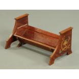 An Arts & Crafts mahogany book trough, inlaid with brass and pewter with stylised designs,