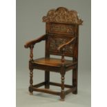 A late 19th/early 20th century carved oak Wainscot chair, with carved panelled back,