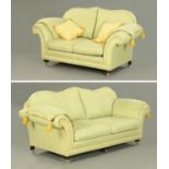 A pair of settees, each with rollover arms and with loose cushions.