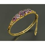 A Victorian silver gilt five stone amethyst hinged bangle,