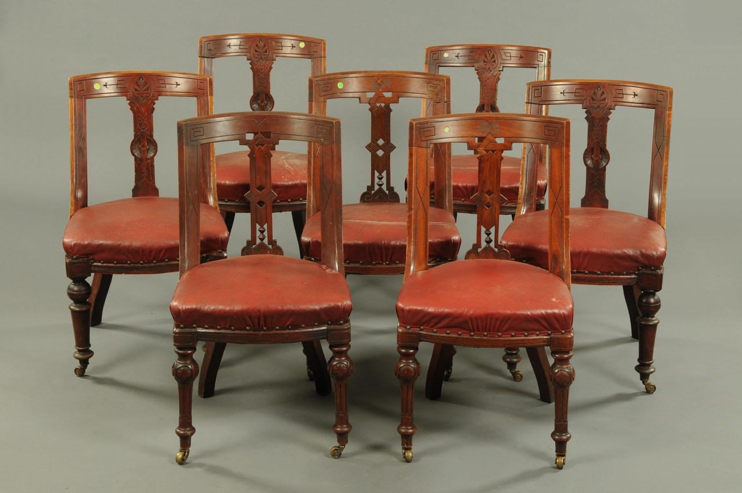 A matched set of seven Victorian mahogany dining chairs, each with incised bowed top rail,