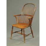 A 19th century stick back Windsor armchair, with long seat and raised on turned legs.