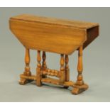 A reproduction Jacobean style small oak gate leg table, with canted angles,