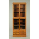 An oak Minty style bookcase, in two sections, with two pairs of glazed doors and drawers to base,