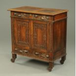 An early 20th century carved oak cabinet, with carved frieze,
