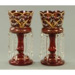 A pair of 19th century cranberry glass lustres, with faceted drops. Height 30.5 cm.