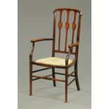 An Edwardian inlaid mahogany armchair, with upholstered seat raised on turned legs with stretchers.