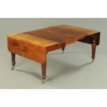 A Victorian mahogany twin drop flap dining table with two centre leaves,
