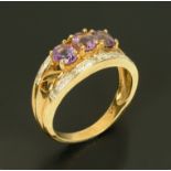 A 9 ct gold three stone amethyst ring, with diamond accents set in white gold, size N.