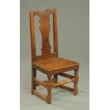 An antique oak occasional chair, with splat back, solid seat and stretchers.