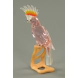 A Swarovski crystal cockatoo, pink, with wooden stand, Roland Schuster.