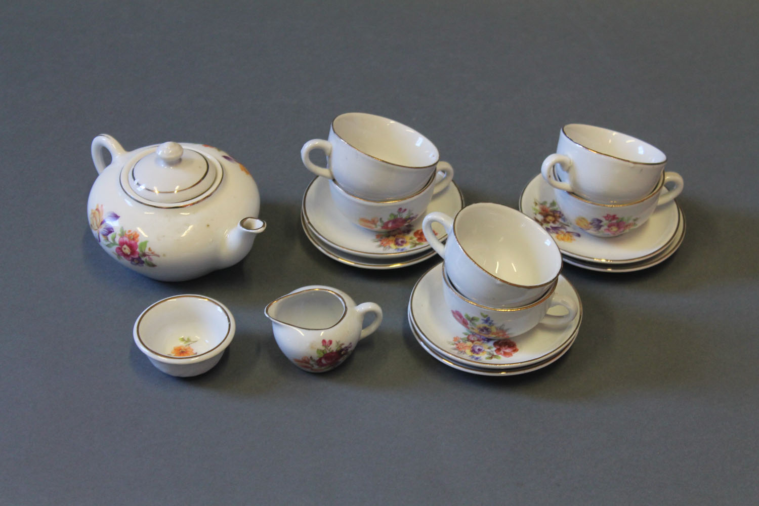 A Victorian floral decorated child's tea set comprising teapot, six tea cups, six saucers,