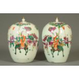 A pair of 19th century Chinese polychrome lidded vases, decorated with figures.