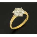 An 18 ct two tone gold seven daisy cluster ring, set with diamonds weighing +/- 1 carat, size M/N.