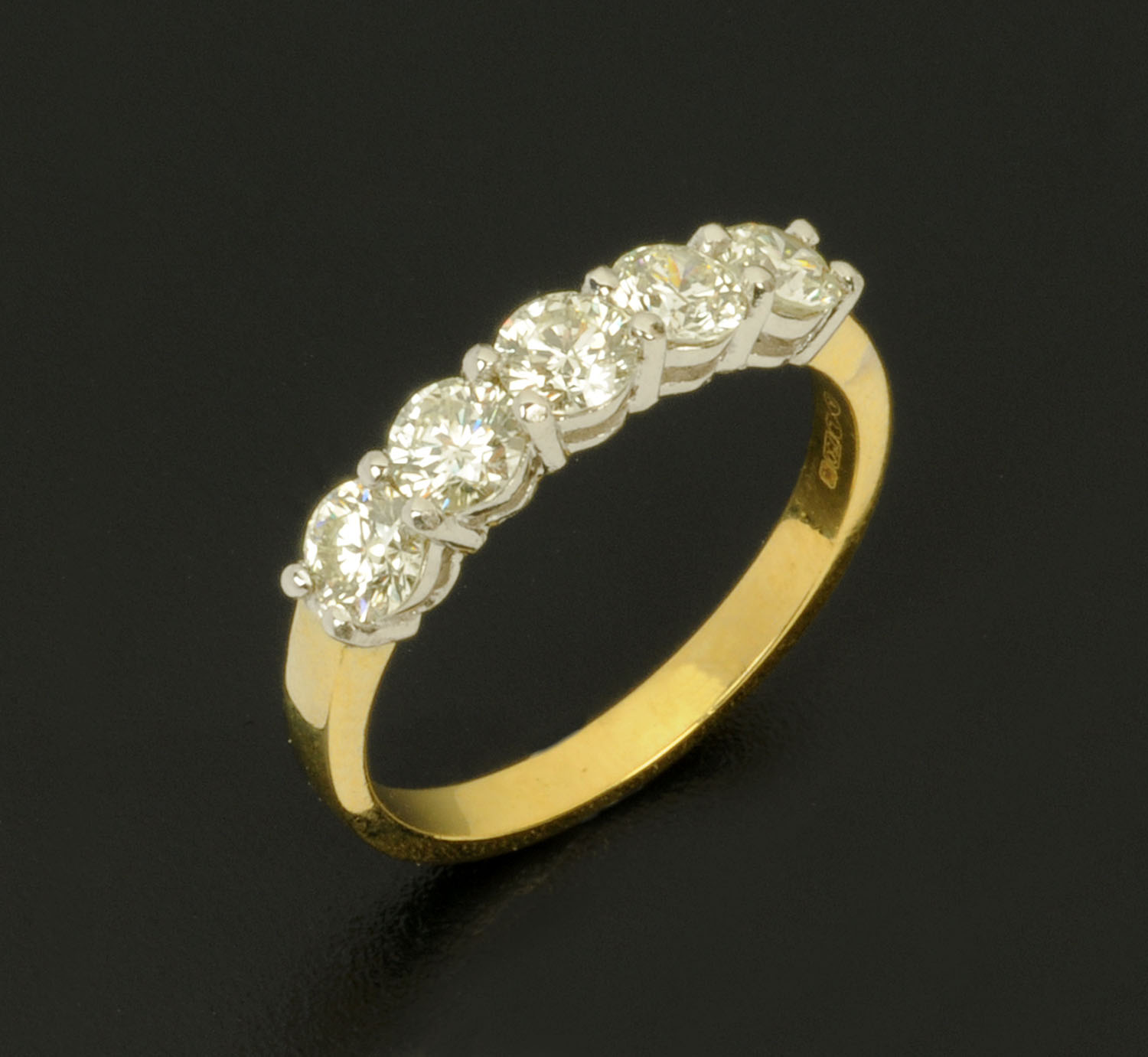 An 18 ct two tone gold five stone half eternity ring, set with diamonds weighing +/- 1.