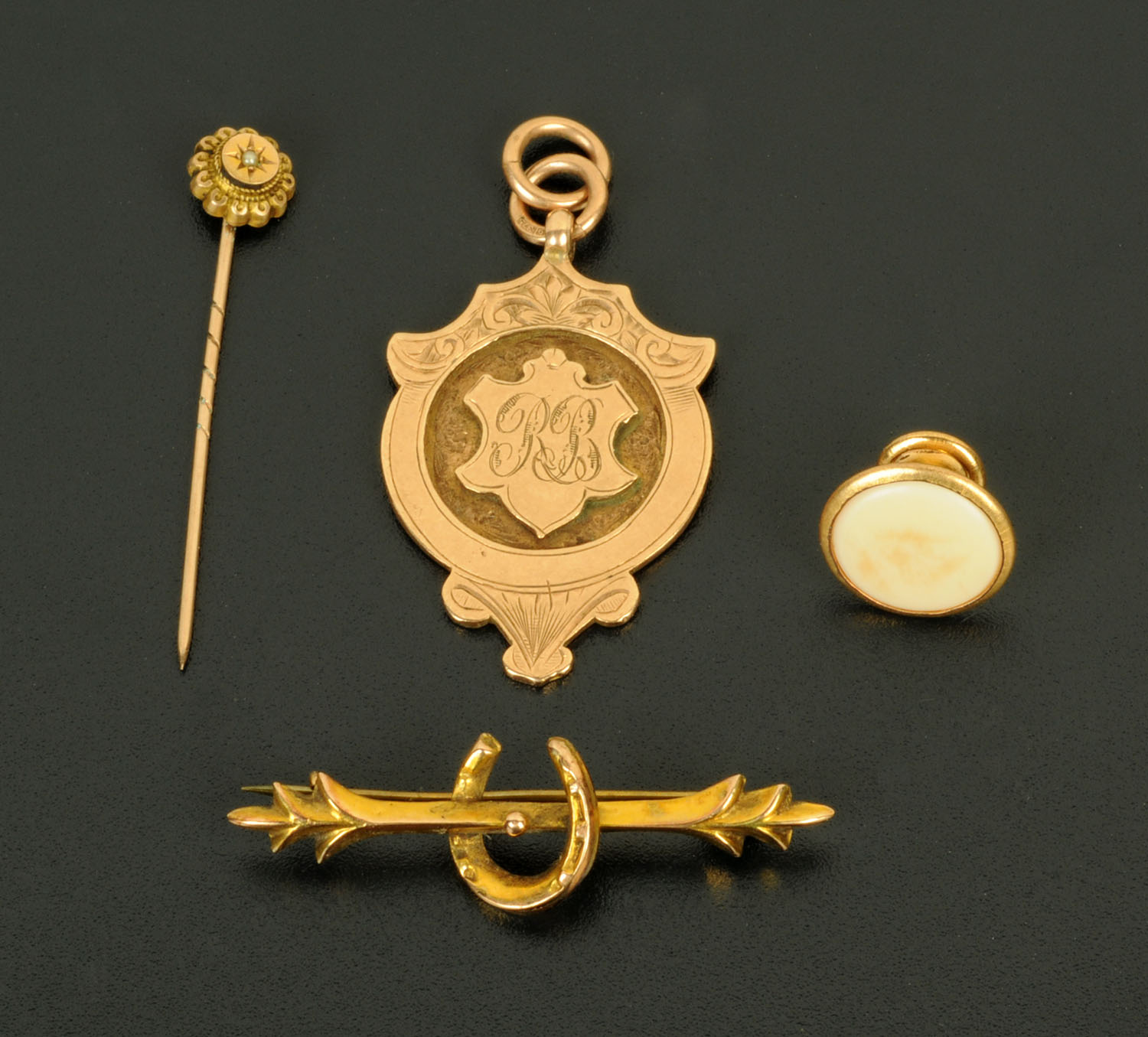 A 9 ct gold watch fob, 8.1 grams, and a stick pin, stud and 9 ct gold horseshoe stick pin.