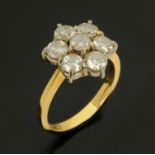 A 18 ct gold seven stone diamond daisy cluster ring, size N/O, hallmarked and stamped 2.