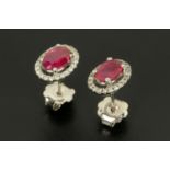 A pair of 18 ct gold oval ruby and round brilliant cut diamond cluster stud earrings,