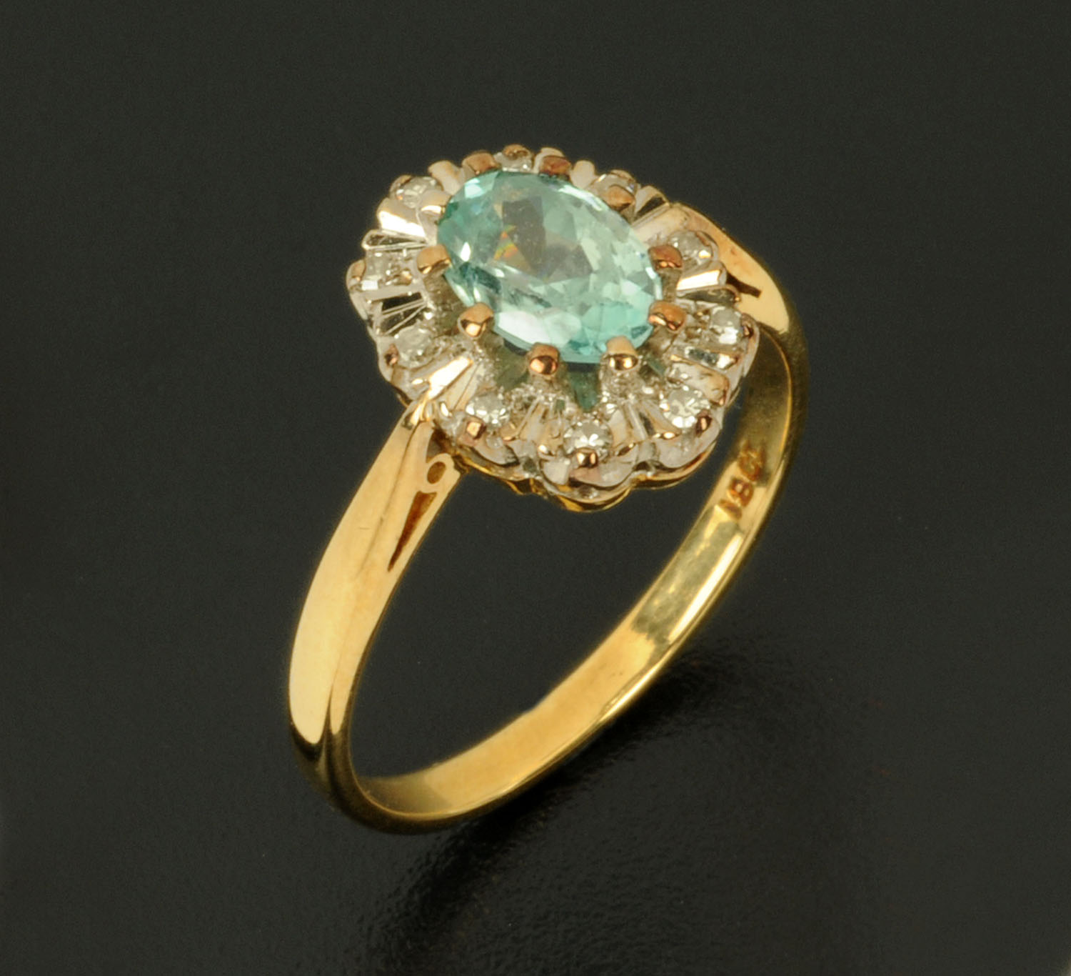 An 18 ct gold aquamarine and diamond cluster ring, oval, stamped "18 ct", size N.