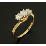 An 18 ct yellow gold three stone diamond ring, with crossover setting.