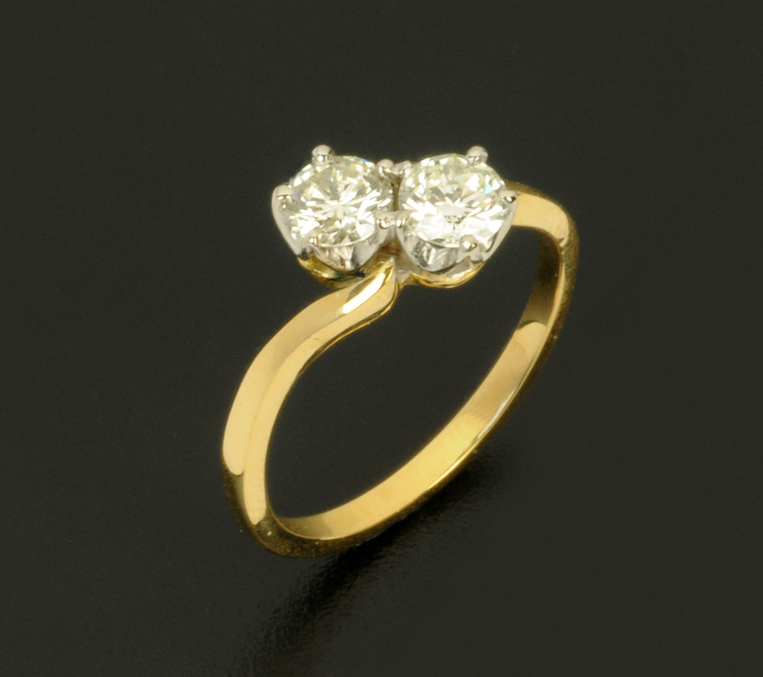 An 18 ct two tone gold crossover set ring, set with diamonds weighing +/- .